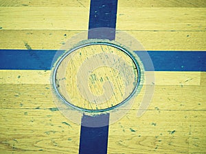 Circle cover for training equipment in floor of school gym. Painted lines