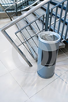 Circle cylinder grey trash can with plastic bag inside on floor