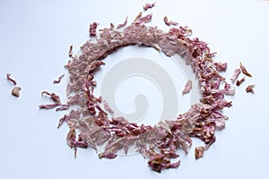 a circle frame made of dried sakura petals on white background,