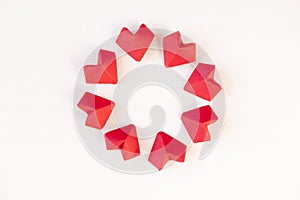 Circle frame from red origami hearts on white background, above. 14th February Valentine`s day or wedding invite
