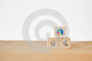 Circle graph showing market share portion on wooden cube blocks with  shopping cart and increasing percent symbol included copy