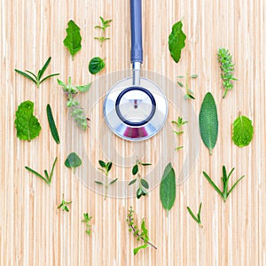 The circle of Herbs leaf and flower with stethoscope on wooden t