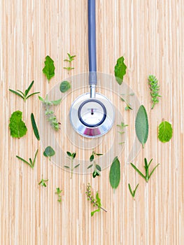 The circle of Herbs leaf and flower with stethoscope on wooden t