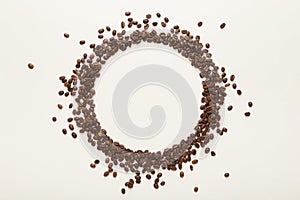 Circle made of coffee seeds on white isolated background