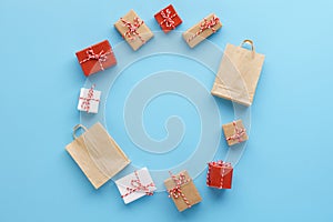 Circle made of gift boxes and shopping bags on blue background