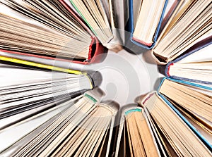 The circle made of old hardback books on white table, top view. Search for relevant and necessary information.