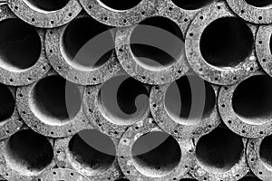 Circle pattern of rusty steel pipes in black and white