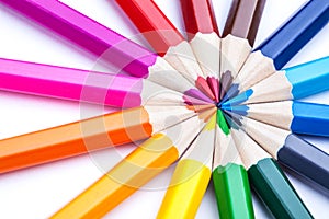 A circle of sharpened colored pencils on a white background.