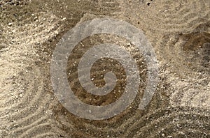 Circles on multitoned brown sand surface