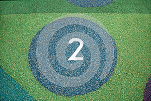 Circles with numbers made of rubberized coating of green blue purple color on the playground