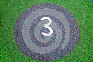 Circles with numbers made of rubberized coating of green blue purple color on the playground