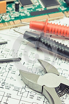 Circuit board with transistors, resistors, capacitor. Diagram of electronics, cable of multimeter and precision tools