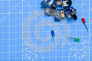 Circuit-boards and blue, gree and red led electrical components on blue background.