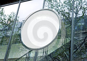 Circular billboard Mockup on glass window. Round empty frame on company building frontage photo