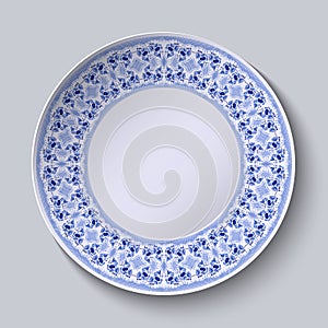 Circular blue flower pattern with empty space in the center. White porcelain plate with a stylized pattern in ethnic style.