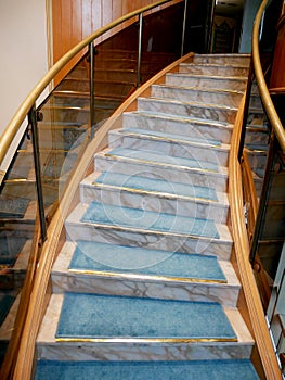 Circular marble staircase with blue carpet