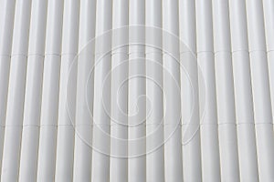 Circular metal structure made of several white tubes as a cladding for an outer wall of an external wall background concept