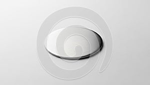 A circular metallic disc placed on a smooth light colored surface