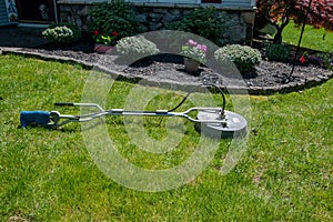 Circular pressure washer with hose attached on a green grass lawn