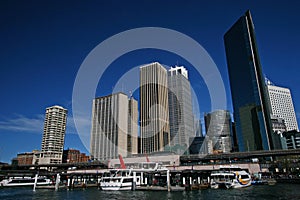 Circular Quay cityscape, Sydney Harbor. City waterfront. Iconic skyline of downtown skyscrapers. Ferries in water. CBD coastline