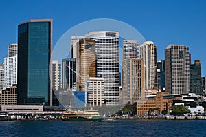 Circular Quay cityscape, Sydney Harbor. City waterfront. Iconic skyline of downtown skyscrapers. Ferry in water. CBD coastline