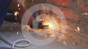 Circular saw cuts metal slow motion. Worker cutting metal with circular saw with sparks flying around. Construction concept