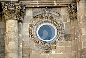 Circular wooden window in renaissance stone facade