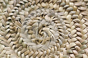 Circular woven straw background in beige and sand colors