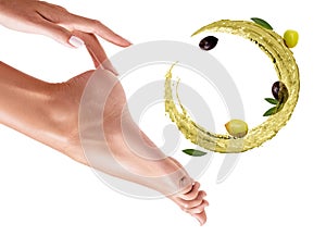 Circulate splash of olive oil near female feet. Skincare concept. photo