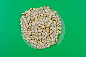 circulo de pistachos sobre fondo verde photo