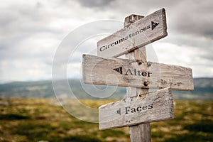 circumstances alter faces text engraved on old wooden signpost outdoors in nature