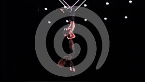 Circus aerial cube duo on black background performing tricks. Man and women fly on stage