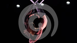 Circus aerial cube duo on black background performing tricks in slow motion. Man and women fly on stage