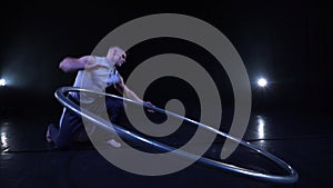 Circus artist dancing in slow motion with metal wheel. concept of movement and flowing time