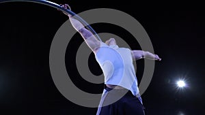 Circus artist dancing in slow motion with metal wheel. concept of movement and flowing time