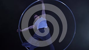 Circus artist dancing in slow motion with metal wheel. concept of movement and flowing time