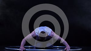 Circus artist dancing in slow motion with metal wheel. concept of movement and flowing time