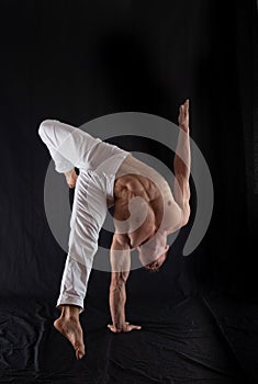 circus artist keeps balance on one hand  on a black background. Concept of individuality, creativity and self