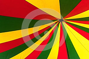 Circus tent in green, yellow and red, view from below in the top