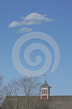 Cirrus clouds hover over red cupola on a sunny, blue-skied day