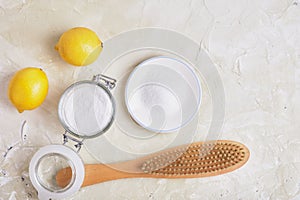 Citric acid, soda, lemons and a wooden brush on a light background for eco cleaning, natural and non-toxic detergents, zero waste