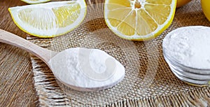 Citric acid on a wooden background with lemon. Selective focus