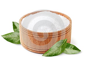 Citric acid in wooden plate with green leaves on white background, isolated. Lemon acid