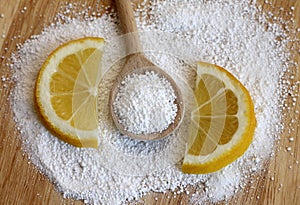 Citric acid in wooden spoon with lemon