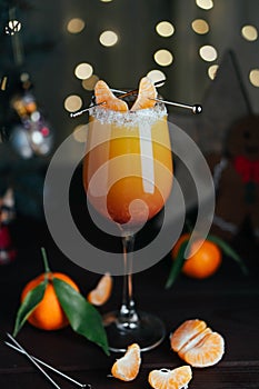 Citrus alcohol coctail with orange tangerine juce and grenadine in wineglass with slice of mandarine on top