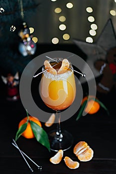 Citrus alcohol coctail with orange tangerine juce and grenadine in wineglass with slice of mandarine on top