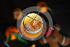 Citrus alcohol coctail with tangerine juce and grenadine in wineglass with mandarine slice. Top view