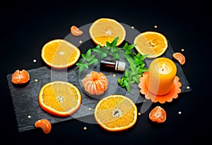 Citrus aroma oil concept Ã¢â¬â glass bottle with essence, tangerine and orange slices