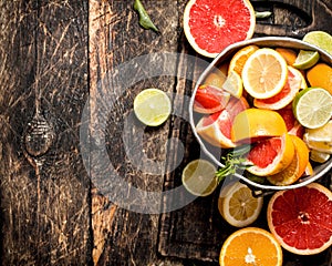 Citrus background. Fresh citrus fruits in the old bucket.