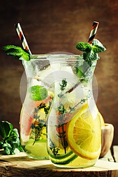 Citrus cool lemonade in glass jugs, vintage wooden background, s
